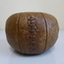 This is a brown leather medicine ball with leather lacing.