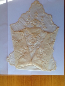 This is a silk embroidered hankerchief, cream in colour.