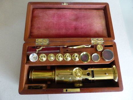 This is a brass microscope in a lined wooden box.