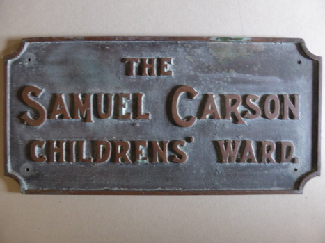 This is a rectangular brass plate with raised lettering.