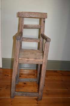 This is arustic homemade child's highchair.