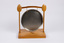 Front of dinner gong suspended by two wooden spoons attached to wooden stand.