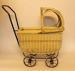 White wicker child's pram with black metal frame.
