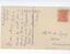 Cream postcard with ink inscription on left side, written sideways, and address and red stamp on the right side. 
