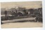Postcard in yellowing monochrome depicting a large arch bridge spanning over water with buildings in background. Two men sitting on bench in front of bridge
