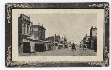 A postcard of a streetscape with a horse and cart travelling in the direction of the viewer