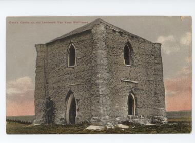 Image of Bear's Castle at Yan Yean. Two-Storey castle-like building of cob (mud and straw) construction with arch windows. Man in hat and coat and holding a walking stick is standing in front.