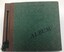 Dark green book with brown binder threaded with green cord.