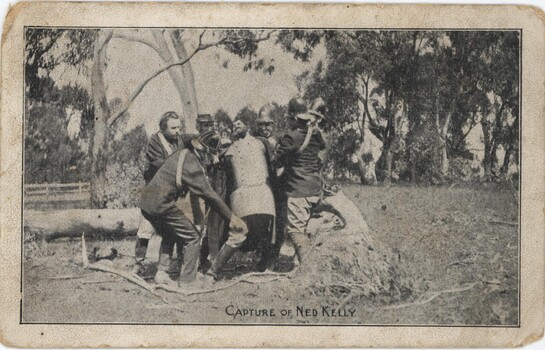 Postcard depicting six policemen detaining a man in a metal suit (Kelly).
