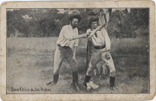 Two men in white shirts pointing guns to a directly slightly right of camera.