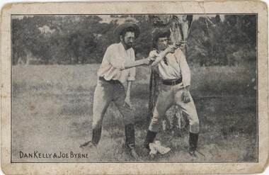 Two men in white shirts pointing guns to a directly slightly right of camera.