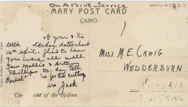 The back of a postcard, with cursive text that is damaged in some areas.