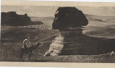 Postcard depicting a man in a robe on a camel, in front of the Great Sphinx of Giza statue.