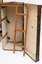Steamer trunk open and in vertical position with hanger leaning against it