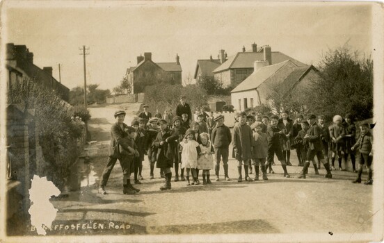 A group of children standing on a street in a Welsh village.