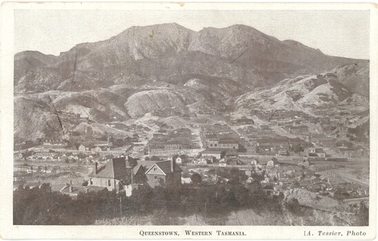 Scenic view of Queenstown, Tasmania showing large and small buildings and houses with Mt Owen in the background.