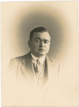 Sepia head and shoulders portrait of Ian MacLeod Murphy wearing suit and tie.