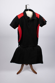 Front of netball uniform with red and black top and black skirt