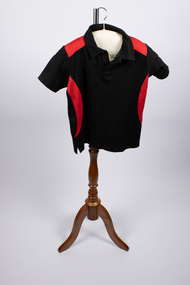 Front view of netball uniform top - black and red colors