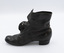 The image shows the left-hand side of the right shoe from a pair of black button-up boots. The image shows some scuffing on the heel.