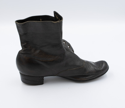 Image shoes the right-hand side of the left boot from a pair of black button-up boots.