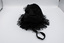Top view of black drawstring bag with tassels and handle prominent.