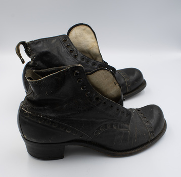 A pair of black low-heeled boots with their right sides facing the camera.
