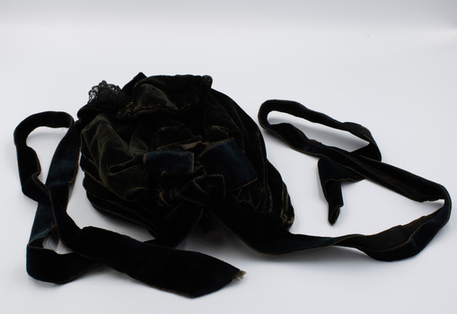 Back of black velvet hat with two black ribbons for tying under chin