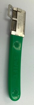 Bean cutter with green plastic handle and metal cutting end both inscribed with maker's marks.