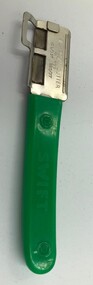 Bean cutter with green plastic handle and metal cutting end both inscribed with maker's marks.