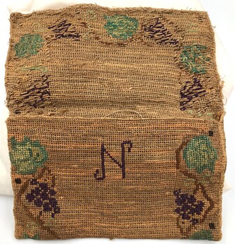 Handmade hessian bag fully open with embroidery around all the edges and an embroidered letter 'N' in the centre.