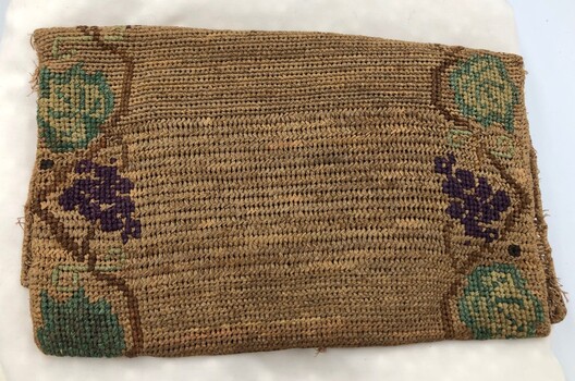 Back of closed handmade hessian bag with embroidery lining the two side edges.