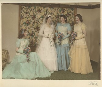 Bride with three bridesmaids, one seated and two standing with the bride all carrying posies. Two bridemaids are dressed in blue and one in yellow.