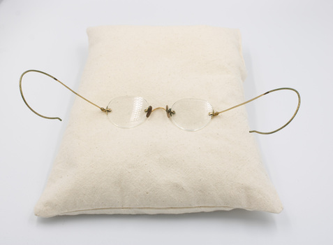 Bi-focal glasses displayed on a cushion  