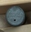Top of needle case with small dispensing hole and inscriptions visible.