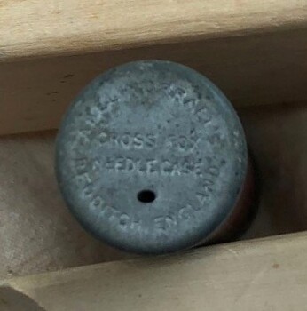 Top of needle case with small dispensing hole and inscriptions visible.