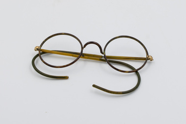 Broken pair of metal spectacles with no lenses
