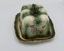 Side view of cheese cover and plate with floral design and gold rim around plate edge.