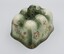Two sides of rectangular ceramic cheese cover showing ornate design with floral decoration on the sides and handle on the top.