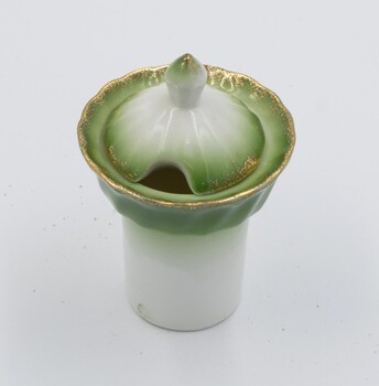 Ceramic salt cellar with green band and gold rim on white background.
