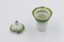 Salt cellar with lid removed and placed next to it. Both have green decorative rim on white background with gold rim around salt cellar.