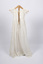Back view of long, cream-colored christening gown on a stand with ties visible