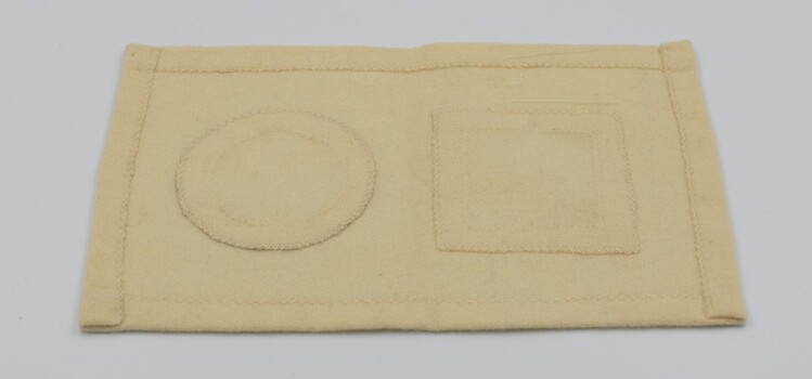 Back of cream-colored sampler showing circle and square.