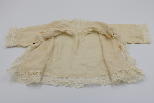 Baby jacket is wide open, and the inside of the jacket is visible. 