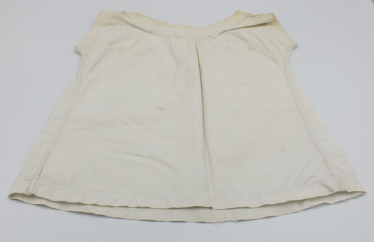Back of crea-colored baby bodice with round neckline.