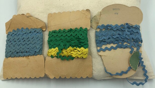Back of three packets with Ric Rac trim - two with blue trim and one with green trim and yellow trim.
