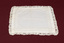 Other side of white lace-trimmed handkerchief laid flat.
