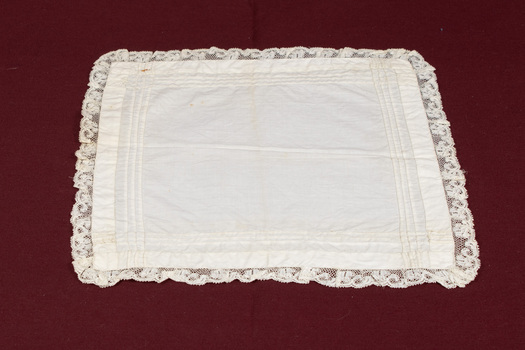 Other side of white lace-trimmed handkerchief laid flat.
