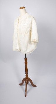 Angled view of ladies jacket, cream-colored, on mannequin.