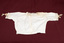 Lace-trimmed cream-colored child's blouse laid flat.